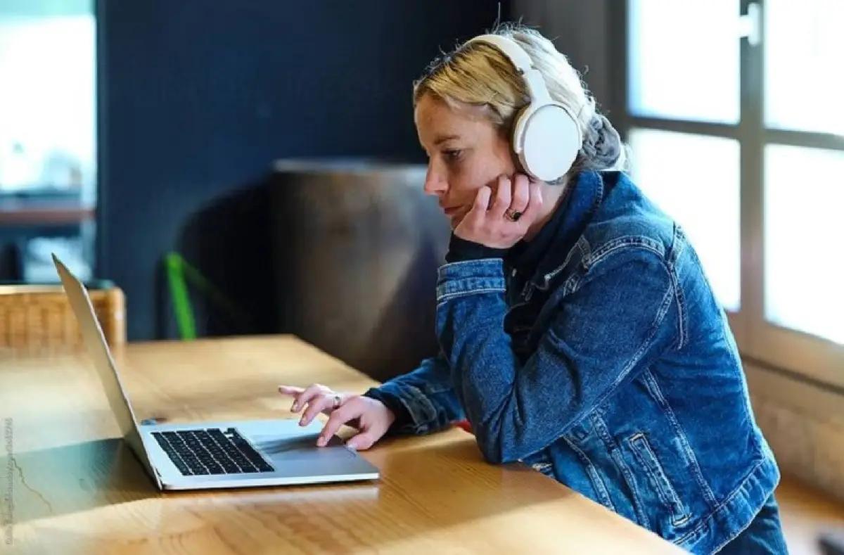 Ilustrasi menggunakan headset dengan fitur noise cancelling untuk meredam bising berlebih di tempat umum. (FOTO: stocksy.com)